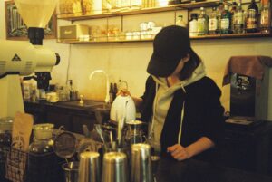 a woman standing at a counter in a coffee shop
