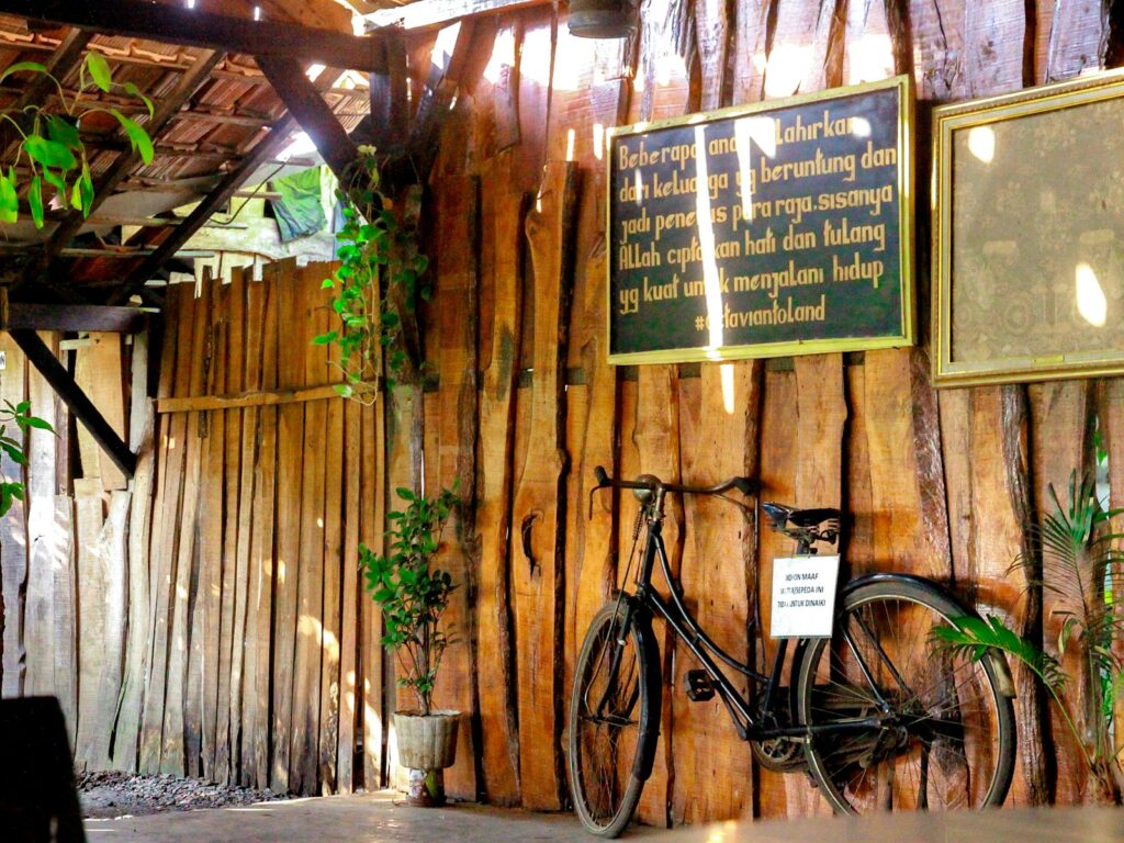 A bicycle is parked against a wooden wall