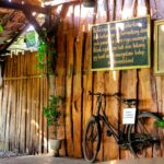 A bicycle is parked against a wooden wall