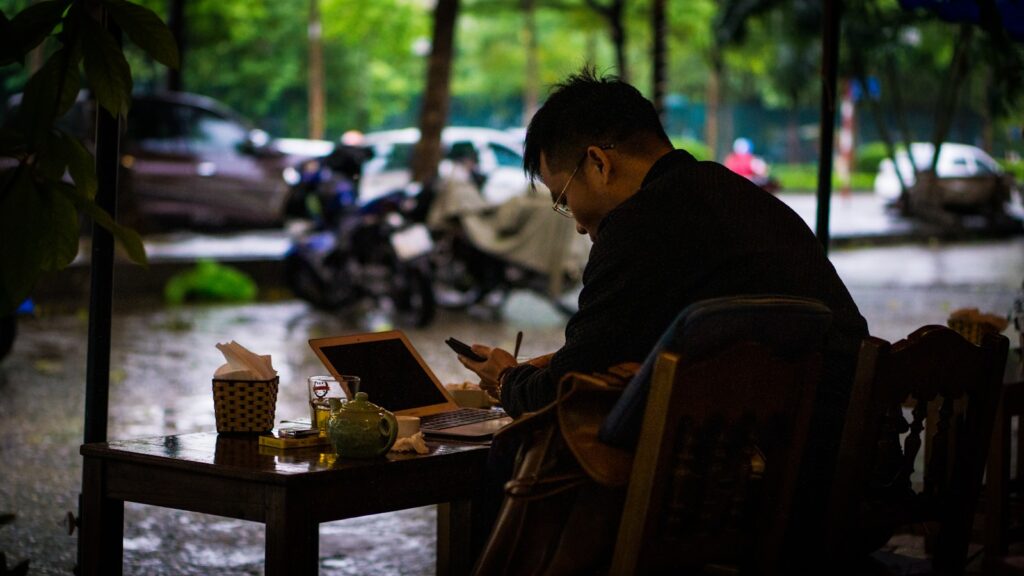 a man sitting at a table with a laptop computer
