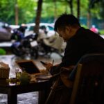 a man sitting at a table with a laptop computer