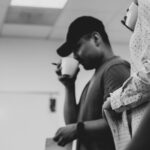a black and white photo of a man holding a cup of coffee