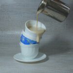 white and blue ceramic mug with stainless steel spoon