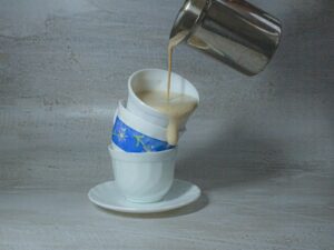 white and blue ceramic mug with stainless steel spoon