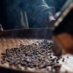 a close up of a person stirring coffee beans